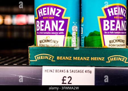 London, UK, 19. Oktober 2026, Nahaufnahme von Dosen mit Heinz-Bohnen und Richmond-Fleischwurst auf einem UK-Supermarktregal mit Preisschild Stockfoto