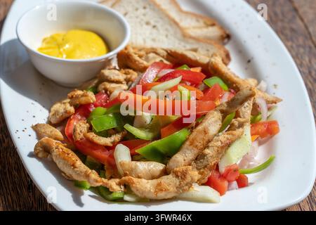Gebratenes Hähnchenfilet mit Gemüse und Brot auf einem weißen Teller, nah dran Stockfoto