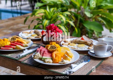 Tropisches Frühstück mit Obst, Kaffee, Rührei und Bananenpfannkuchen für zwei Personen am Strand in der Nähe des Meeres im Hotelrestaurant, Insel Sansibar, Tansania Stockfoto