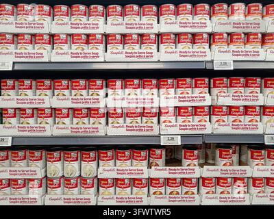 Campbells-Suppendosen säumen die Regale in einem Supermarktgang, gestapelt für Kunden während der Öffnungszeiten. Stockfoto