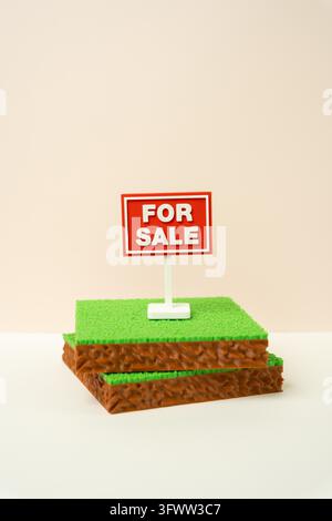 Grundstücke und ein „Zu verkaufen“-Schild. Landverkauf. Immobilientransaktionen, Immobilieninvestitionen, Eigentumsübertragung und Entwicklungschancen. - Fotomontage Stockfoto