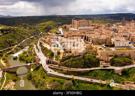 Idyllische Luftaufnahme der Stadtlandschaft von Toledo auf grünen Hügeln des Tajo-Flusses im frühen Frühling mit Blick auf die befestigte Alcazar-Burg, eingerahmt von vier zu Stockfoto