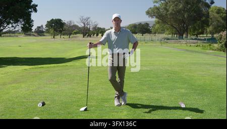 Kaukasischer Mann genießt einen sonnigen Tag auf dem Golfplatz Stockfoto