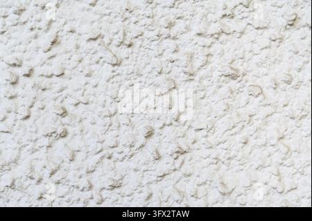 Raue weiße Stuckwandtextur mit Unebenfläche in detaillierter Nahaufnahme. Stockfoto