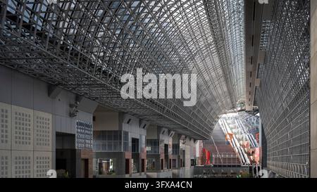 Ein großes Dach aus Stahl und Glas überspannt das geräumige Innere des Bahnhofs Kyoto in Japan Stockfoto
