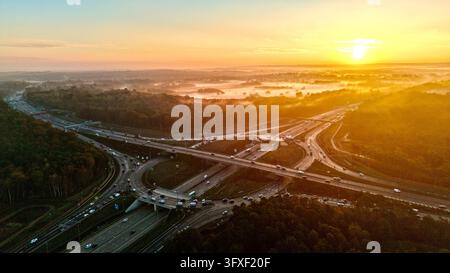 Drohnenluftbild der M25-Abfahrt 10 und des Surrey-Waldlandes bei Sonnenaufgang, England Stockfoto