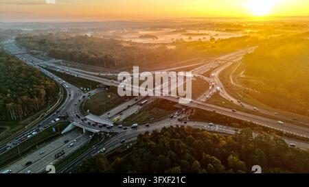 Luftbilddrohnenaufnahme des Verkehrs an der M25-Abfahrt 10 und der A3-Kreuzung im goldenen Sonnenauflicht, Surrey, England Stockfoto