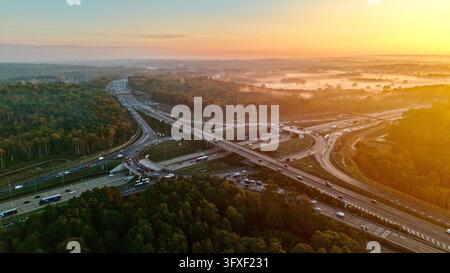 Luftbilddrohne-Ansicht der M25-Kreuzung 10 und Morgendunst über dem Waldland von Surrey, England Stockfoto