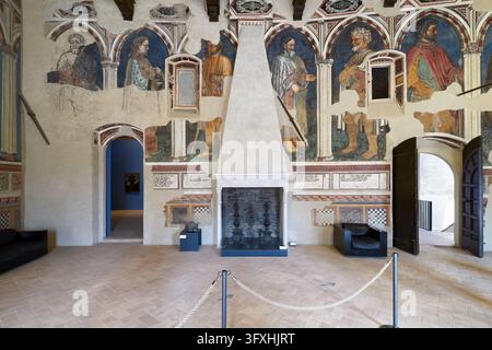 Spätgotische Fresken von stehenden Figuren und ein pyramidaler Kamin in der Sala dei Giganti des Palazzo Trinci, Foligno, Umbrien, Italien Stockfoto