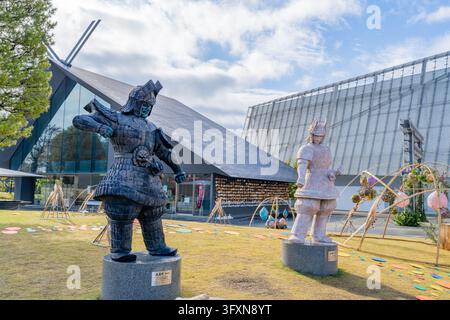 Tokio, Japan, 22. NOV 2024 - Zwei große Daimajin-Statuen stehen auf einem Rasen vor dem eckigen Kadokawa-Musashino-Museum unter einem bewölkten Himmel. Stockfoto