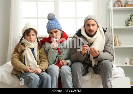 Familien-Gesundheitsvorsorge und saisonale Krankheiten, kranke Eltern und Kind mit Erkältungs- und Grippesymptomen, die während der Wintersaison zu Hause Medizin und Nasenspray verwenden Stockfoto