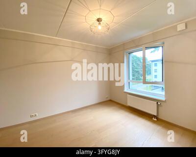Leeres modernes Schlafzimmerinterieur mit hellem Holzboden, beigen Wänden und Fenster. Ein leeres modernes Rauminterieur mit beigen Wänden, hellem Holzboden, einem Wi Stockfoto