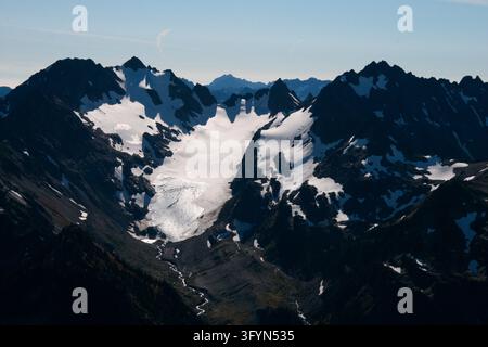 Eine Luftaufnahme, die den Eel-Gletscher auf dem Mount Anderson im Olympic National Park, Washington, USA, zeigt. Die Hochgebirgsperspektive präsentiert die dramatische vergletscherte Alpenlandschaft und hebt Spalten, Schneefelder, schroffe Berggipfel und tiefe Täler hervor, die für die Pazifikküste im Nordwesten charakteristisch sind. Eine optimierte Version eines Bildes des US National Park Service. Credit: NPS Stockfoto