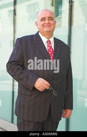 Reife Geschäftsmann vor Glas verkleideten Gebäude. Stockfoto