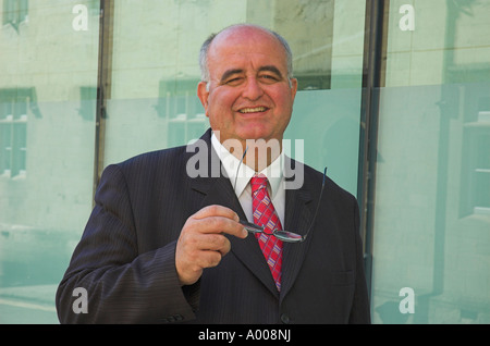 Reife Geschäftsmann vor Glas verkleideten Gebäude. Stockfoto