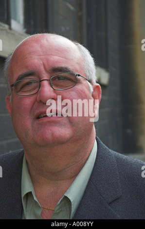 Porträt eines leger gekleidet Kaufmanns stehen gegen eine Steinmauer Stockfoto