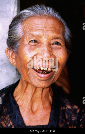 lachend Seniorin Stümpfen der verfaulten Zähnen bei einer Feuerbestattung Zeremonie in Bali anzeigen Stockfoto