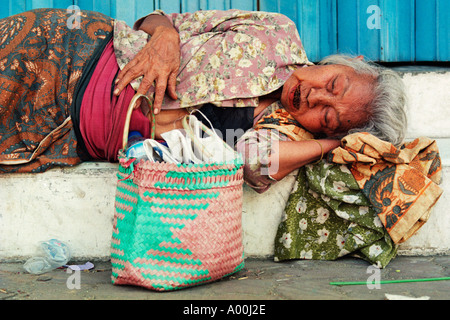 ältere Obdachlose Frau schläft am Tag entfernt auf einer Straße in Madiun Ost Java Indonesien Stockfoto
