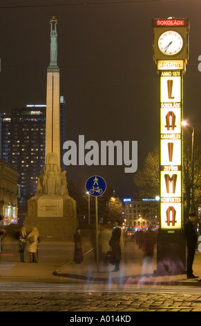 Laima-Uhr und Freiheit-Denkmal in der Nacht mit den 27 Geschichte russische gebaute Hotel Latvija im Hintergrund Stockfoto