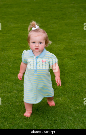 Vierzehn Monate altes Mädchen auf dem Rasen im Park Stockfoto