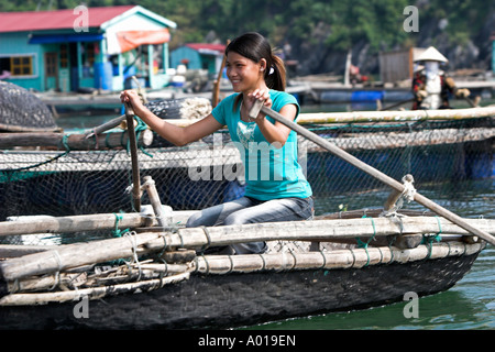 Konische Hut Frau Reihen traditionelle gewebte Boot herum schwimmenden Fischen Dorf Cat Ba Stadt Bucht Nord-Ost-Vietnam Stockfoto