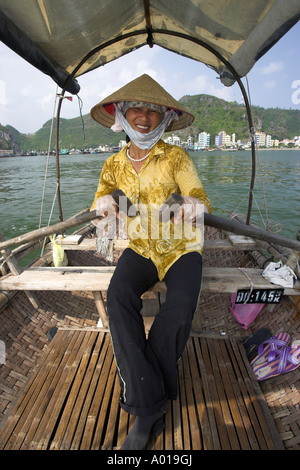 Konische Hut Frau Zeilen Touristen herum schwimmenden Fischerdorf im traditionellen gewebten Boot Cat Ba Stadt Bucht Nord-Ost-Vietnam Stockfoto