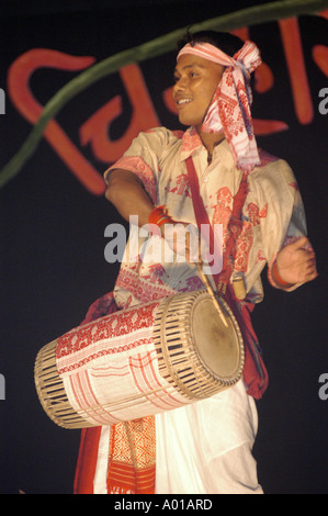 Mann, der während des traditionellen Assam Bihu-Tanzes beim Namchi Festival in Sikkim, Indien, Trommeln spielt. Er trägt ethnische Kleidung und ein Kopftuch. Stockfoto