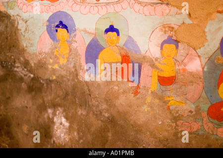 Antike verwitterte alte, vom Wasser zerstörte Buddha-Wandmalereien auf einer zerbröckelnden Wand, die historische religiöse Kunst und beschädigte Fresken zeigen. Stockfoto