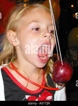 Kind versucht, den ersten Biss einen Apfel nehmen Stockfoto