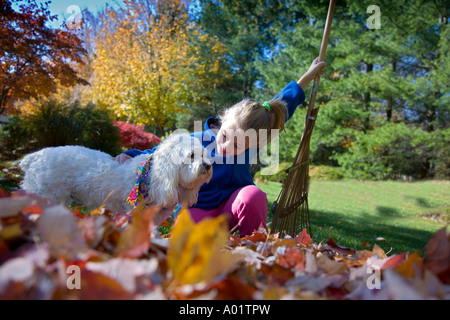 Kind spielt mit ihrem Hund an einem Herbsttag Stockfoto