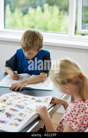 Bruder und Schwester Lesebücher am Tisch zu Hause Stockfoto