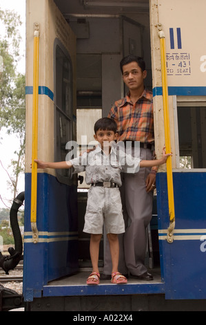 Indischer Vater und Sohn stehen in der Tür des Kangra Spielzeugzugs in Himachal Pradesh, Indien. Stockfoto