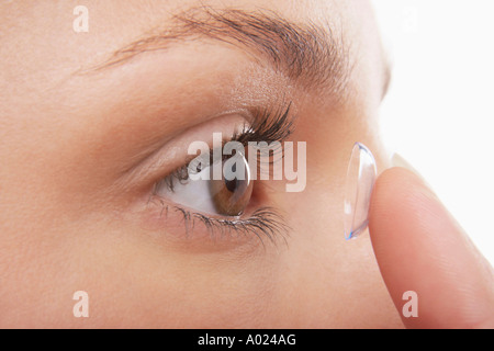 Junge Frau in Kontaktlinsen setzen Stockfoto