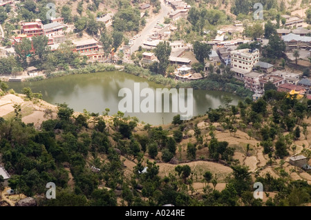 Panoramablick auf den TSO Pema See in Revalsar, Indien, mit dem heiligen See, der von Dorfgebäuden und Terrassenhügeln umgeben ist. Stockfoto