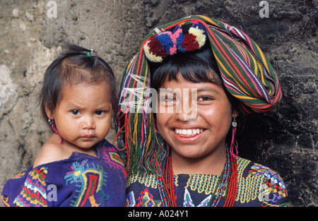 Junge Maya-Frau trägt die genähten Kostüm ihrer Gemeinschaft halten Babys Chajul Ixil Dreieck El Quiche Guatemala Stockfoto