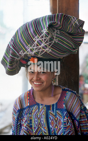 Ixil Maya Mädchen ein großes Bündel auf dem Kopf balancieren und gelbgrundigen typische Kleid von Chajul Guatemala Stockfoto