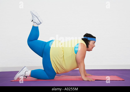 Übergewichtige Frau am Boden tun aerobe erstreckt sich Stockfoto