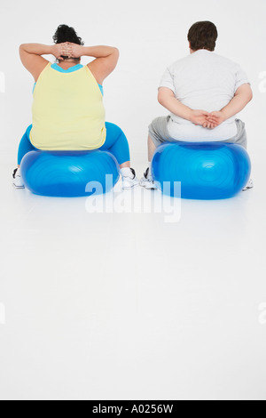 Übergewicht, Mann und Frau übt auf Gymnastikbälle, Ansicht von hinten Stockfoto