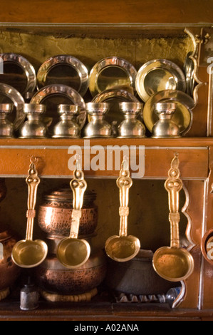 Traditionelle Messingtöpfe und -Utensilien im Inneren von ladakhi Kitchen, ladakh, Indien. Rustikales Kupferzeug und Metallplatten auf Holzregalen. Stockfoto