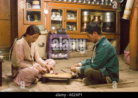 Ladakhi Mann und Frau mittleren Alters bereiten gemeinsam Essen in einer traditionellen Küche im Dorf Basgo, Ladakh, Indien zu. Stockfoto