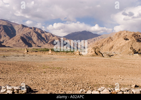 Trockene Wüstenlandschaft mit alten buddhistischen Stupas vor dem Hintergrund zerklüfteter Berge in Ladakh Indien. Stockfoto