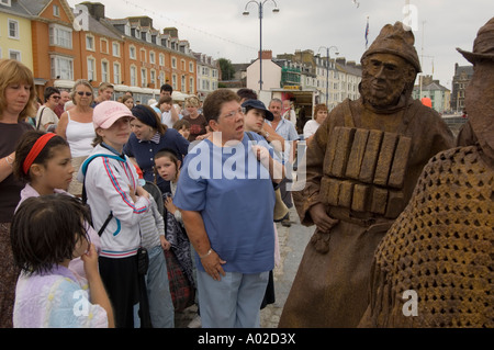 Gaukler die Strangelings durchführen, als bewegte seefahrende Bronzestatuen auf Aberystwyth promenade Stockfoto