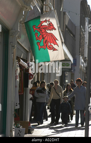 Welsh banner Flagge mit roten Drachen fliegen vor Geschäft am wichtigsten Straße Aberystwyth Ceredigion Wales Cymru UK Stockfoto