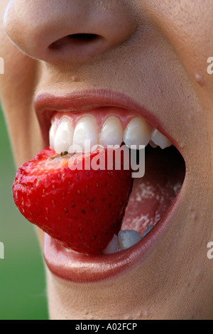 Eine attraktive Teenager genießen eine Erdbeere gesunde Ernährung Stockfoto