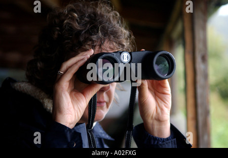 Eine Dame Vogelbeobachtung mit dem Fernglas Bushnell im Arundel Wildfowl and Wetlands Centre Stockfoto