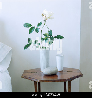 Nahaufnahme der weißen Rose in weiße Vase auf antiken Tischchen im Schlafzimmer Stockfoto