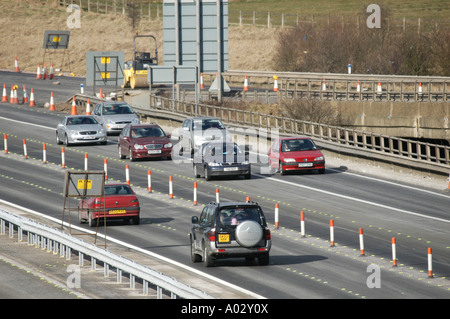 Verkehr durch einen gegenläufigen wegen Straßenbauarbeiten auf der uk-Autobahn fahren Stockfoto