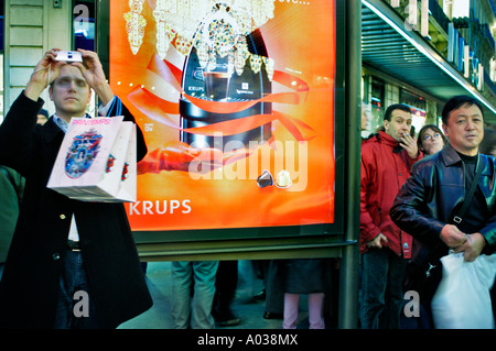 Paris Frankreich, Männern, die Fotos auf der Strasse, Weihnachtszeit, bis Suchen, Winter Shopping, Weihnachtsbeleuchtung, Dekorationen, chinesische Touristen Stockfoto