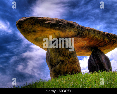 Kleiner Stein Megalith auf einem grasbewachsenen Hügel unter einer erschreckend tief, strukturiert und blauen Himmel. Stockfoto