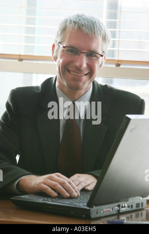 Nahaufnahme von Geschäftsmann lächelnd mit Notebook-computer Stockfoto